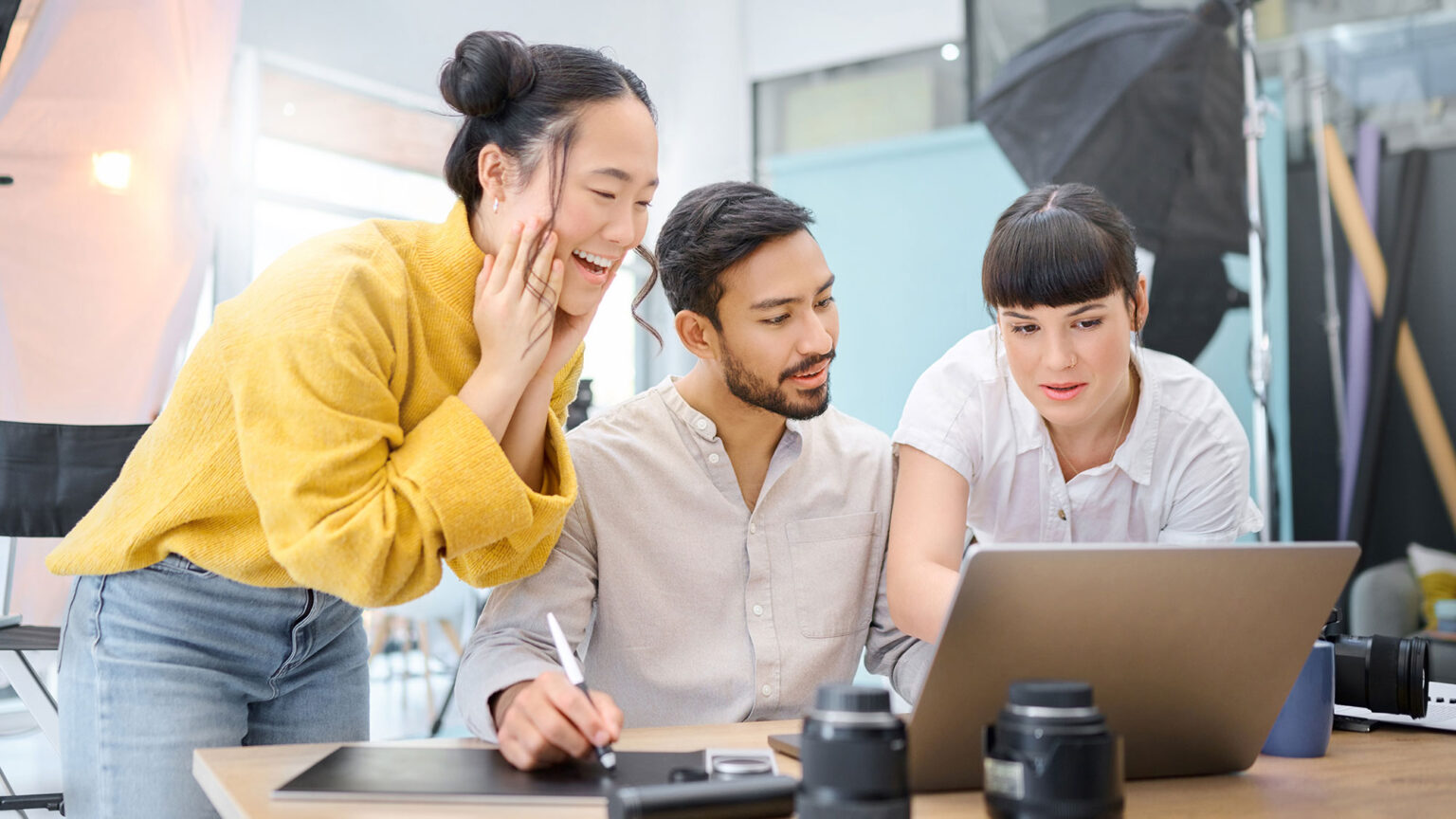 drei fotografen schauen sich etwas auf dem laptop an